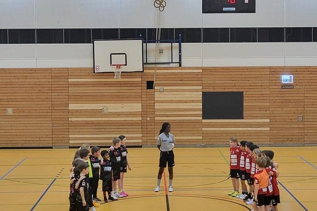 Zwei Gruppen von Kindern in Sportkleidung stehen sich auf einem Handballfeld gegen&uuml;ber, wartend auf den Spielbeginn.