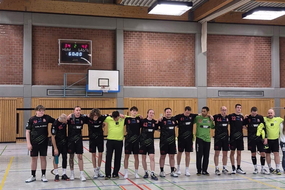 Mannschaftsaufstellung eines Handballteams in einer Sporthalle, das nach dem Spiel in Reihe steht.