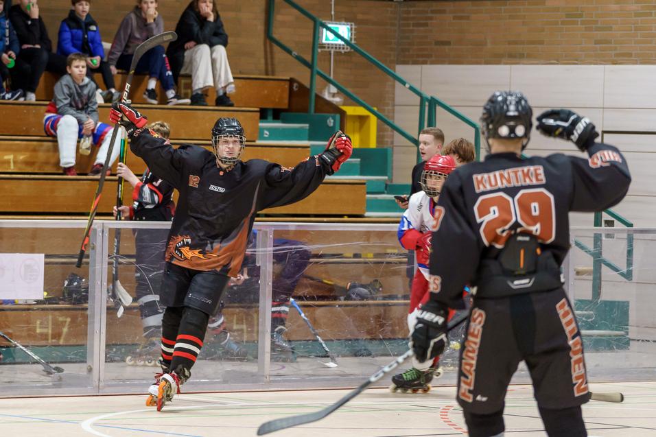 Ein Spieler jubelt nach einem Tor, während ein Mitspieler mit der Nummer 29 am Spielfeldrand steht. Zuschauer im Hintergrund.