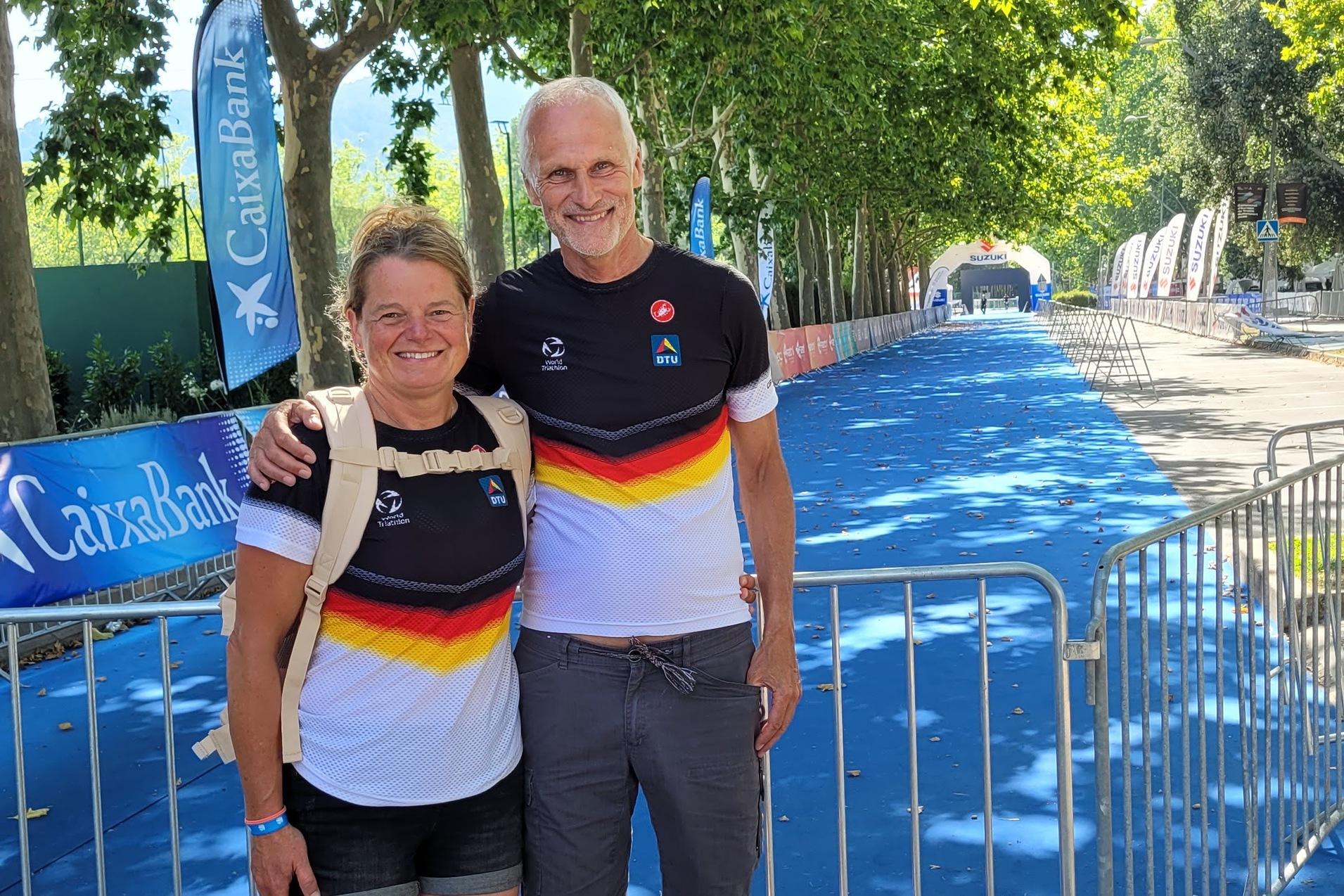 Ein weibliches und ein m&auml;nnliches Sportlerpaar in Shirts mit Deutschlandfarben stehen vor einer blauen Wettkampfbahn.