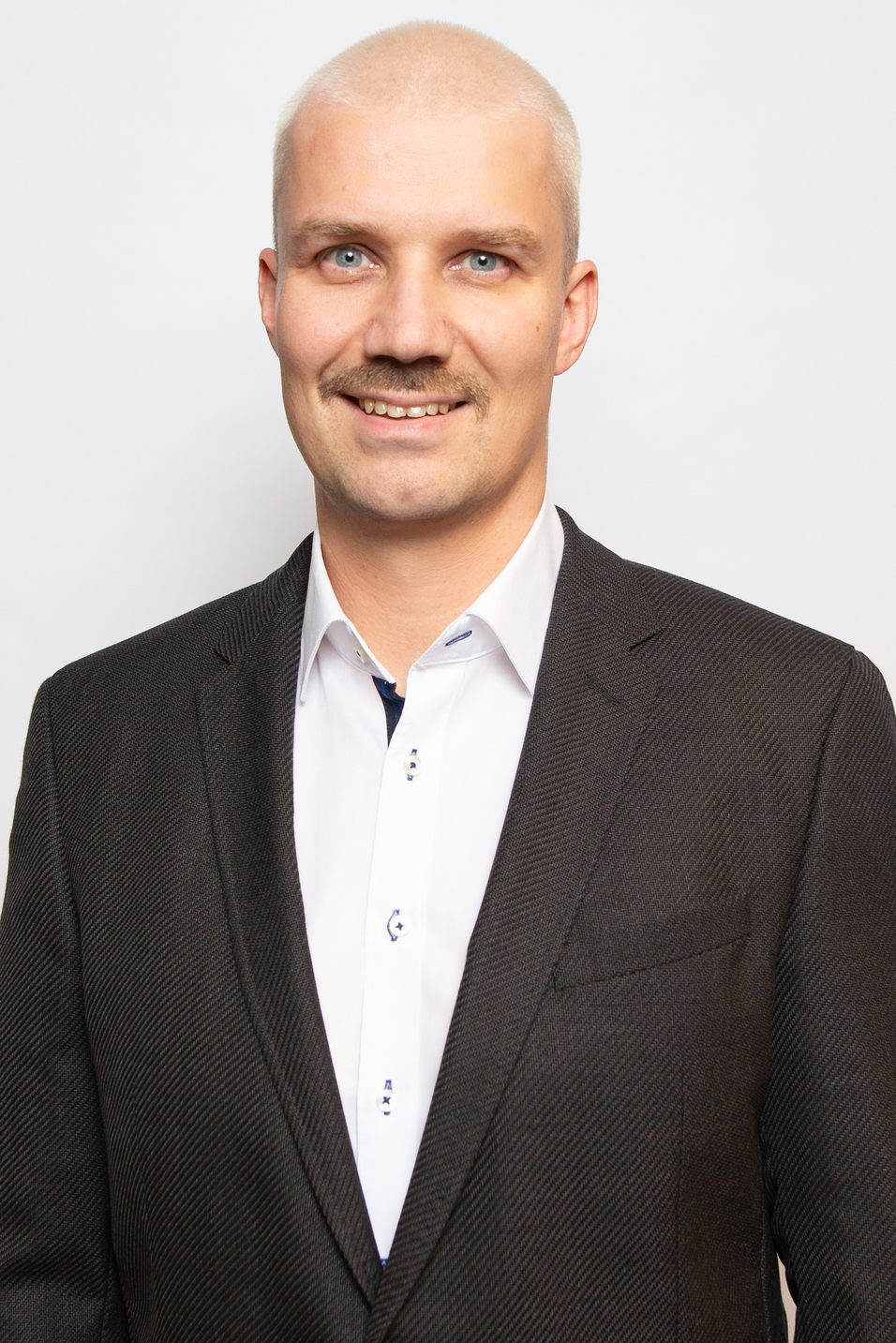 Portr&auml;t eines Mannes mit hellem Haar, blauen Augen und einem Schnurrbart, gekleidet in Anzugjacke und Hemd.