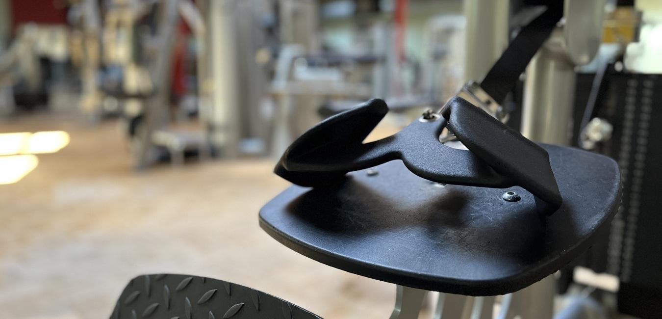 Nahaufnahme eines Fitnessgerät mit Fußstütze in einem modernen Fitnessstudio.
