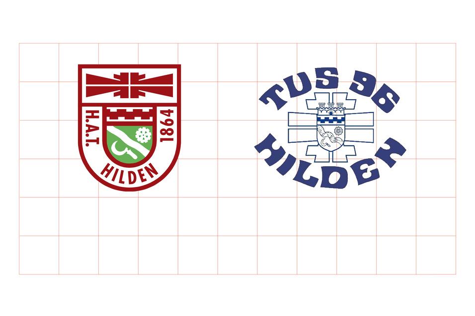 Zwei Wappen: links das rote Emblem von H.A.T. Hilden 1864, rechts das blaue Logo von TuS 96 Hilden.