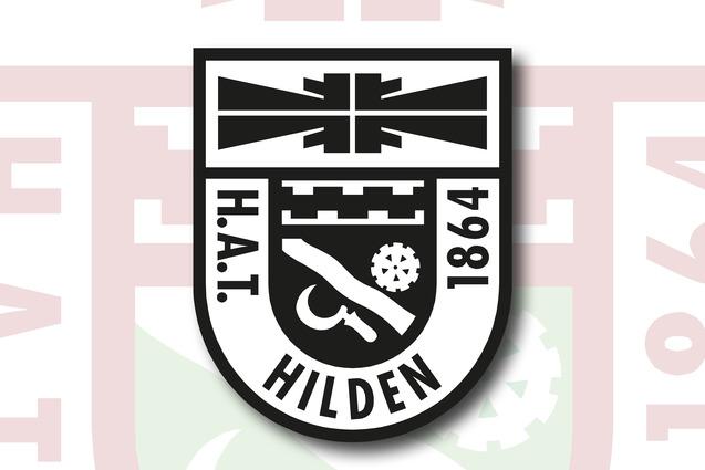 Wappen von H.A.T. Hilden 1864, schwarz-wei&szlig; mit symbolischen Elementen auf einem roten Hintergrund.
