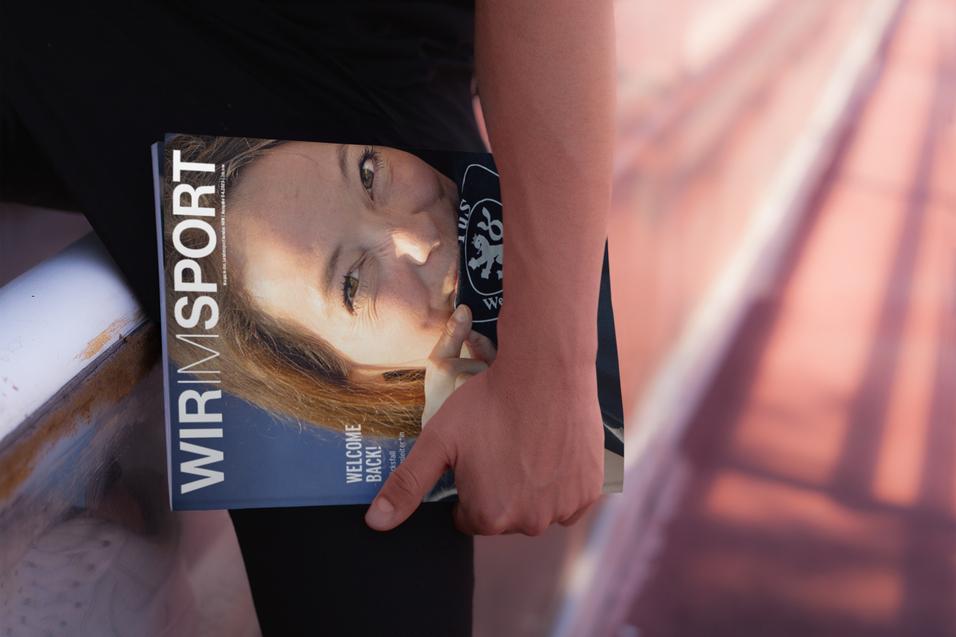 Eine Person h&auml;lt ein Magazin mit dem Titel &bdquo;WIR IM SPORT&ldquo; und einem Portr&auml;t einer Frau im Freien.